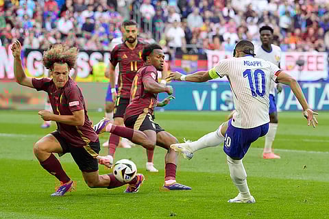 Wout Faes blocks a shot by Kylian Mbappe